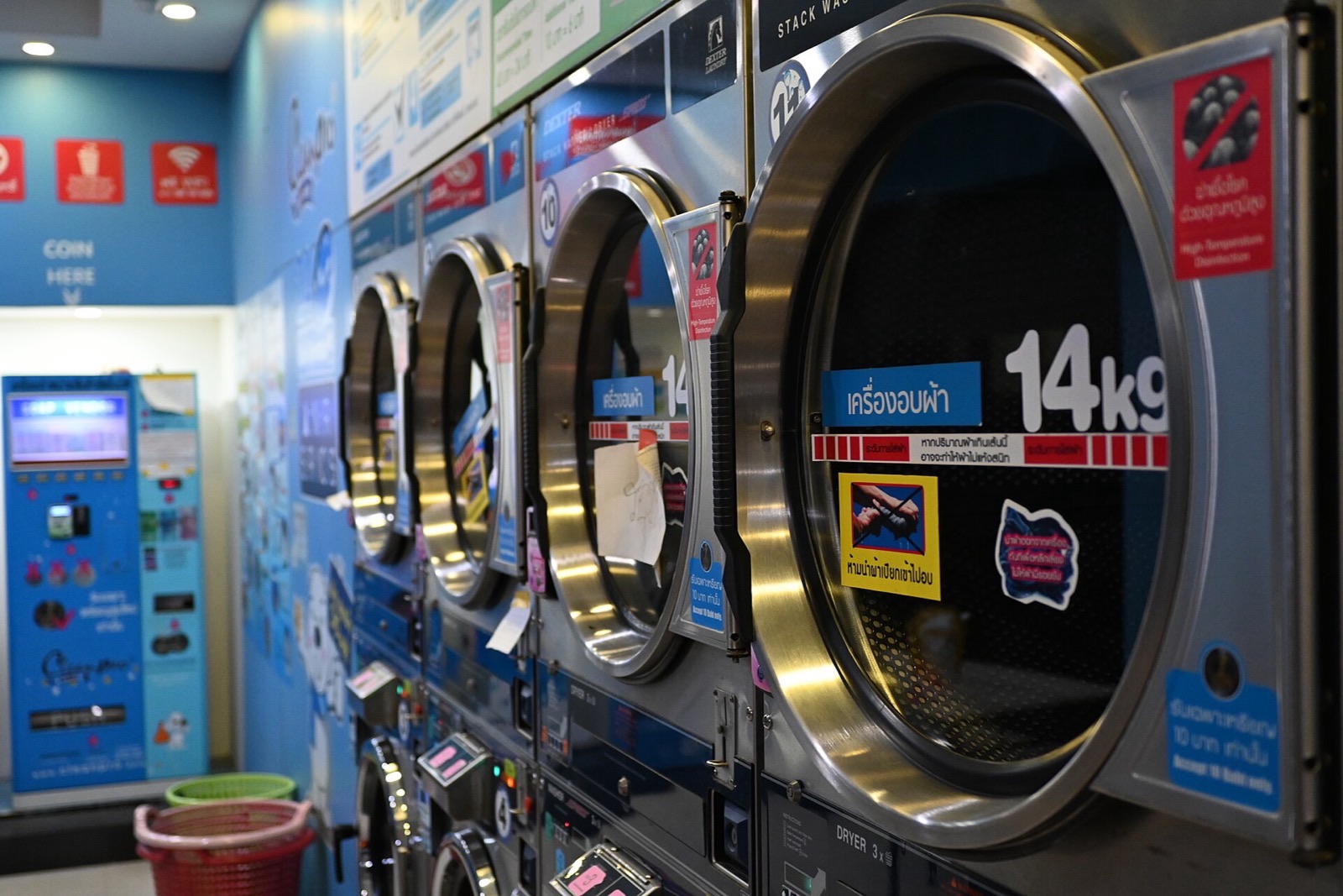 Interior of a self-service laundromat with a row of washing machines